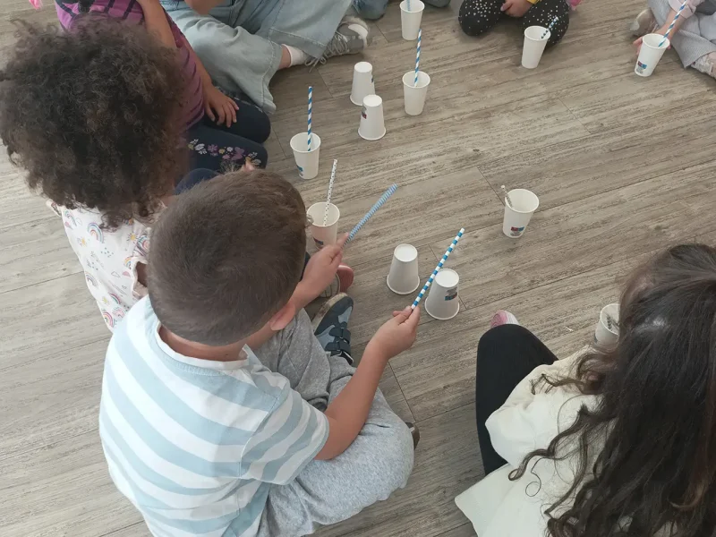 Kinder halten Strohhalme und Becher in den Händen und bereiten sich auf das musikalische „Geblubber“ vor.