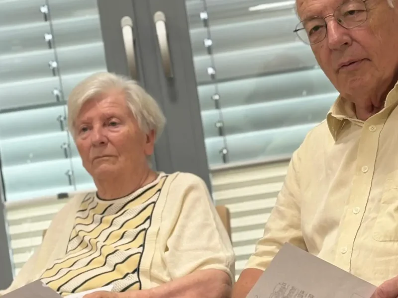 Zwei Senior:innen hören aufmerksam Beethovens Pastorale mit Notenblättern in der Hand.