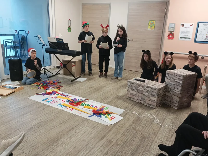 Schüler der Klasse 6a tragen Gedichte vor, während Bewohner des Pflegeheims ihnen aufmerksam zuhören.